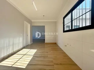 Hall de entrada com piso de madeira e grande janela.