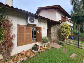 Fachada de uma residência em Lajeado, Brasil, com jardim e telhado de cerâmica.