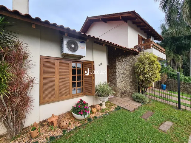 Fachada de uma residência em Lajeado, Brasil, com jardim e telhado de cerâmica.
