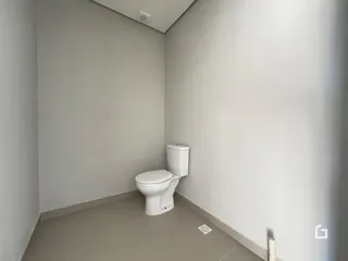 Corredor interno com um vaso sanitário branco.