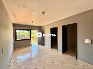 Hall de entrada com piso de cerâmica e portas escuras.