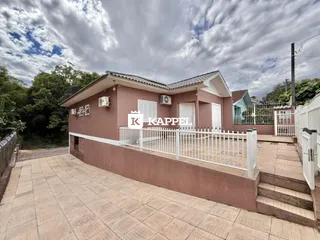 Fachada de uma casa residencial em Lajeado com muro branco e área pavimentada.