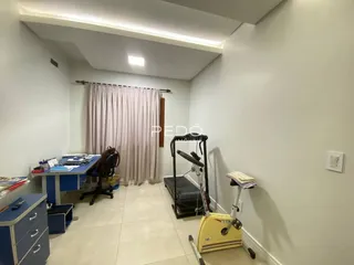 Interior de um corredor com paredes brancas e piso de cerâmica.
