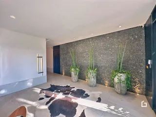 Interior de uma área com parede texturizada e plantas em um imóvel em Lajeado.