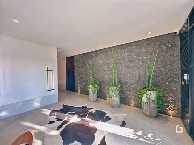 Interior de uma área com parede texturizada e plantas em um imóvel em Lajeado.