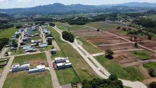 Vista aérea de uma área de terra com campos e construções no Brasil.