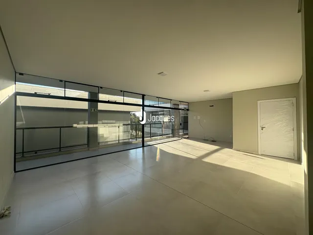 Sala ampla com grandes janelas de vidro.