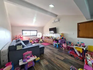 Sala de estar com sofá e brinquedos espalhados no ambiente.