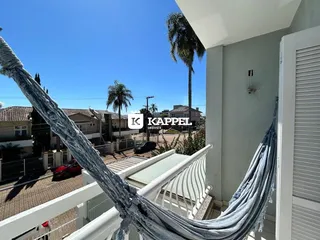 Vista externa de um terraço com grade branca em um bairro residencial.