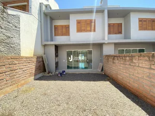 Fachada de uma casa em Lajeado, Brasil, com muro de tijolos e jardim.
