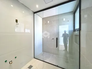 Foto de um banheiro com revestimento de azulejo e box de vidro.