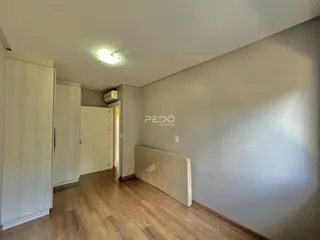 Hall de entrada com piso de madeira e paredes brancas.