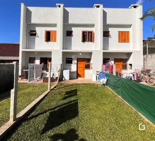Fachada de uma casa branca em Lajeado, Brasil, com quintal gramado.