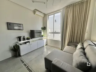 Sala de estar moderna com sofá e janela.