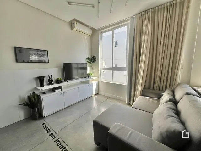 Sala de estar moderna com sofá e janela.