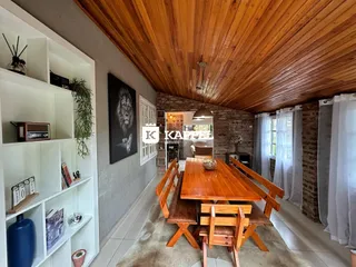 Uma sala de jantar com mesa de madeira e teto de madeira aparente.
