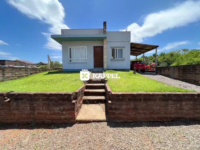 Fachada de uma casa residencial em Lajeado, Brasil, com jardim gramado e muro de tijolos.