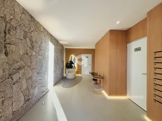Hall de entrada com parede de pedra e revestimento de madeira.
