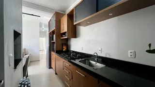 Esta é uma foto de uma cozinha com armários de madeira e bancada escura.