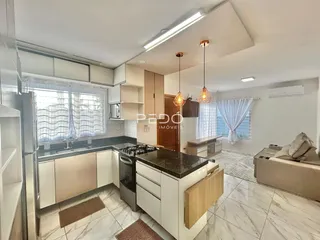 Vista interna de uma cozinha e sala de estar em um imóvel no Brasil.