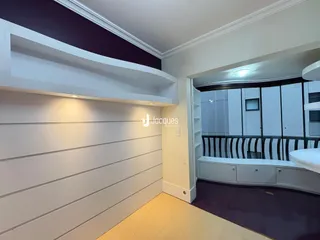 Ambiente interno com painéis brancos e piso de madeira.
