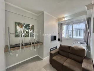 Sala de estar com sofá e janela em apartamento no Brasil.