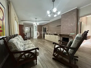 Sala de estar com piso de madeira e móveis de madeira no interior da propriedade.