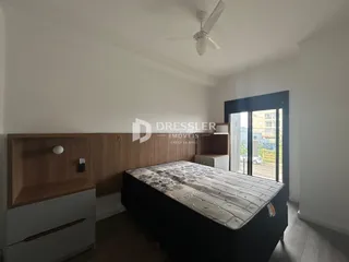 Quarto com cabeceira de madeira e piso de madeira.