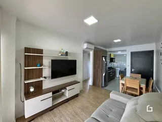 Sala de estar com sofá e painel decorativo em um apartamento.