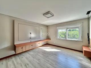 Sala de estar com piso de madeira clara e parede neutra.
