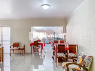 Hall de entrada com piso de madeira e paredes brancas.