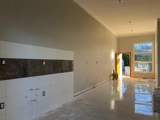 Ambiente interno amplo com piso polido e paredes claras.