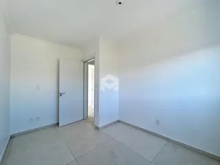 Vista interna de um corredor com paredes brancas e piso claro.