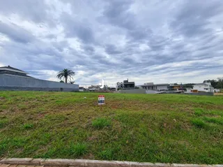 Vista de um campo gramado com uma cerca no primeiro plano.