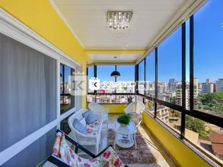 Foto da varanda com cadeiras de vime e vista da cidade.