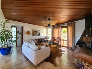 Sala de estar com teto de madeira e acesso ao exterior.