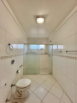 Foto de um banheiro com revestimento cerâmico branco.