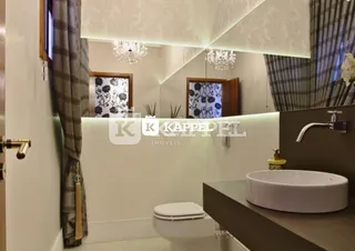 Foto de um banheiro interno com azulejos brancos e cortinas escuras.