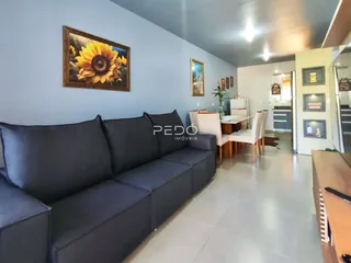 Sala de estar com sofá cinza e piso claro em um imóvel no Brasil.