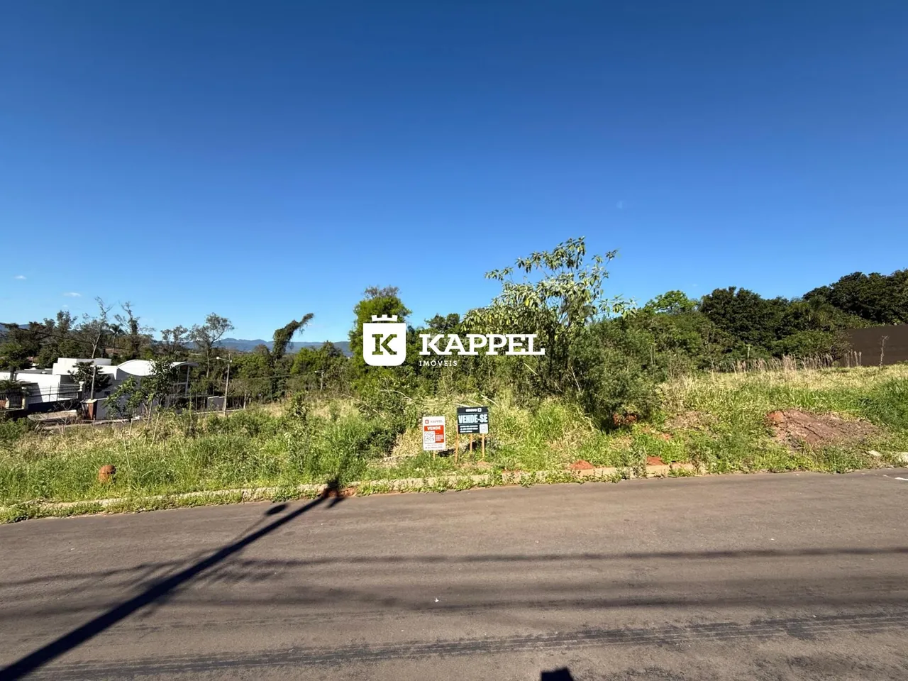 Vista externa de uma propriedade em Lajeado, com vegetação e estrada no primeiro plano.