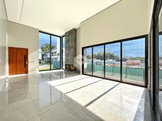 Sala de estar com piso de cerâmica e grandes janelas de vidro.