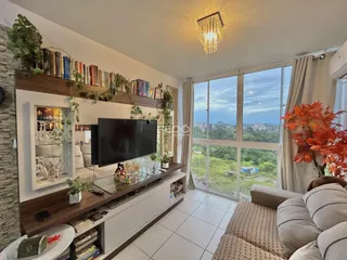Sala de estar com vista para a paisagem externa através de uma grande janela.