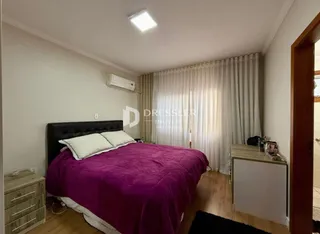 Quarto com cama e cortinas brancas.