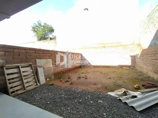Parede de tijolos de uma propriedade em Lajeado, Brasil, com terra no chão.