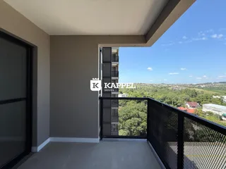 Uma vista panorâmica da paisagem urbana e verde a partir de uma varanda.