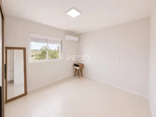 Ambiente interno de uma sala clara com piso de cerâmica e janela.