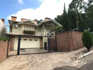A fachada de uma casa em Lajeado, Brasil, com muro de tijolos e portão de ferro.