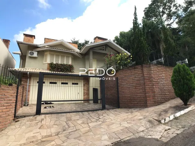 A fachada de uma casa em Lajeado, Brasil, com muro de tijolos e portão de ferro.