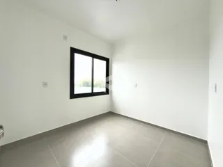 Ambiente interno de uma sala com piso de cerâmica e janela.