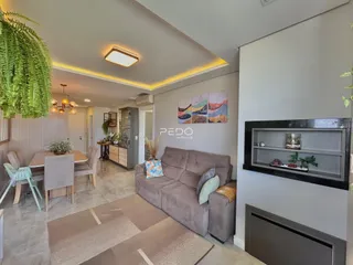 Ambiente interno de sala de estar e jantar com sofá e mesa de jantar.